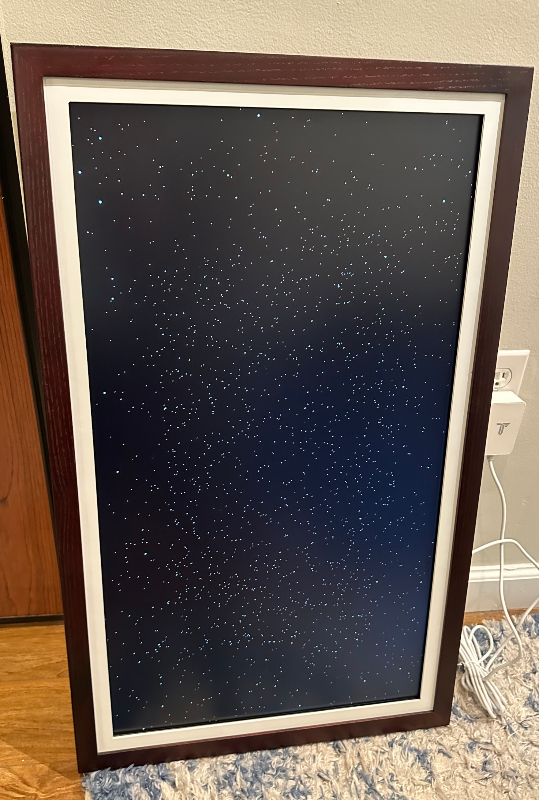 A TokenFrame display is shown with a generic, space-like image of white dots on a black background taking up the full screen
